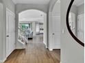 Bright entryway featuring hardwood floors, arched doorways, and staircase that leads to an open-concept living area at 18076 Cider Mill Ln, Winter Garden, FL 34787