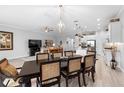 Open-concept dining area with modern furnishings, wood floors, and seamless flow to the living spaces and kitchen at 2017 Flora Pass Pl, Kissimmee, FL 34747