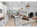 Modern kitchen with white cabinetry, granite countertops, stainless steel appliances, and an island with pendant lighting at 2017 Flora Pass Pl, Kissimmee, FL 34747