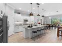 Well-lit kitchen features white cabinets, stainless steel appliances, and a granite countertop island at 2017 Flora Pass Pl, Kissimmee, FL 34747