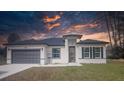 A modern single-story home displaying its gray garage door, modern front door, and landscaped front yard at 245 Marion Oaks Golf Rd, Ocala, FL 34473