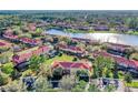 Aerial view showcases the community, highlighting the lake, townhomes, mature landscaping, and convenient parking at 3154 Yellow Lantana Ln, Kissimmee, FL 34747