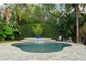 Lush backyard showcasing a refreshing pool with a waterfall feature and tropical landscaping at 3308 Middlesex Rd, Orlando, FL 32803