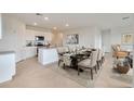 Open-concept kitchen and dining area with a kitchen island and a long table for entertaining at 4585 Boxwood Way, Mount Dora, FL 32757