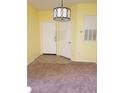 Bright entryway featuring neutral colors and a decorative light fixture, adjacent to a carpeted living area at 5455 Vineland Rd # 3303, Orlando, FL 32811