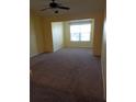 Sunlit living room with carpeted floors and a large window, providing a cozy and inviting atmosphere at 5455 Vineland Rd # 3303, Orlando, FL 32811