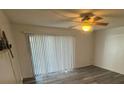 Bright living room with sliding glass doors, wood-look vinyl floors and a ceiling fan at 5951 Village Cir # Ge, Orlando, FL 32822