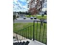 Scenic view from the condo stairs, overlooking a parking area, landscaping and a peaceful pond at 76 Windtree Ln # 201, Winter Garden, FL 34787