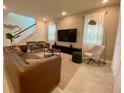 Bright living room with a large TV, comfortable seating, and stylish decor at 8949 Coconut Breeze Dr, Kissimmee, FL 34747