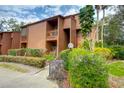 Two-story condo featuring a private balcony, surrounded by lush landscaping and mature trees at 1038 E Michigan St # B, Orlando, FL 32806