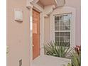 Inviting entryway with decorative light fixture, stylish front door and lush tropical plants at 1208 Bella Rose Ct, Davenport, FL 33896
