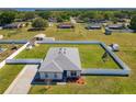 Expansive fenced property featuring a well-maintained lawn, complemented by a detached storage unit and carport at 12524 Garrett Pl, Grand Island, FL 32735