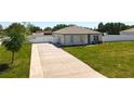 Angle view of home, showcasing driveway, vinyl fence, landscaping, and two car garage at 12524 Garrett Pl, Grand Island, FL 32735