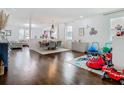Open concept dining area with contemporary lighting, hardwood floors, and a view into the living room and play area at 12627 Boggy Pointe Dr, Orlando, FL 32824