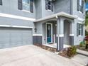 Inviting front porch with a bright blue door, decorative wreath, and attractive landscaping leading to the garage at 12627 Boggy Pointe Dr, Orlando, FL 32824