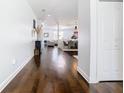 Long hallway with gleaming hardwood floors that leads into a spacious living and dining area in a modern home at 12627 Boggy Pointe Dr, Orlando, FL 32824