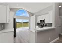 Bright kitchen with stainless steel appliances and a view of the backyard through a large window at 15832 Autumn Glen Ave, Clermont, FL 34714