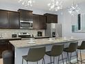 Modern kitchen featuring granite countertops, stainless steel appliances, and bar seating at 2221 Lelani Cir, Davenport, FL 33897