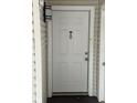 Close up of the condo's front door with a peep hole and overhead light fixture at 2564 Woodgate Blvd # 102, Orlando, FL 32822