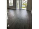 A spacious living room with dark flooring, and sliding glass doors leading to the patio at 2564 Woodgate Blvd # 102, Orlando, FL 32822