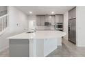 Open kitchen with a center island, stainless steel appliances and grey cabinets at 2811 Alpine Meadow Ln, Kissimmee, FL 34744