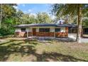 Inviting single-story home with fresh paint, brick accents, and mature trees in a large yard at 2829 Lake Griffin Rd, Lady Lake, FL 32159