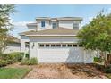 Two-story home with a white exterior, a brick driveway and an attached two-car garage at 3953 Saltmarsh Loop, Sanford, FL 32773