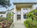 Elegant home entrance with large windows, a decorative door, and vibrant landscaping, creating a welcoming appeal at 450 Blue Smoke Ct, Lake Mary, FL 32746