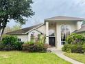 Inviting home entrance with beautiful plants, large windows, and decorative door, enhancing the curb appeal at 450 Blue Smoke Ct, Lake Mary, FL 32746