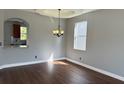Bright dining room boasts a modern chandelier, tray ceiling, and rich dark wood floors at 5768 Los Palma Vista Dr, Orlando, FL 32837