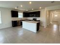 Bright kitchen showcasing an island, tile flooring, and modern appliances at 597 Pine Tree Blvd, Lake Alfred, FL 33850