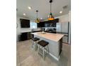 Stylish kitchen featuring a spacious island with pendant lighting and modern appliances at 597 Pine Tree Blvd, Lake Alfred, FL 33850