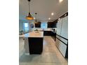 Modern kitchen featuring stainless steel appliances, a large island, and black cabinets at 597 Pine Tree Blvd, Lake Alfred, FL 33850