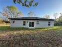 The backyard has a sliding glass door, a gray exterior, and a well-maintained lawn at 6425 Curtis St, Orlando, FL 32807