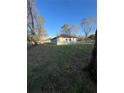 View of the single-story home in a serene setting with a large grassy area at 6425 Curtis St, Orlando, FL 32807