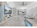 Open concept living room with a large tv, unique textured wall, and marble floors at 7159 Cadiz Blvd, Orlando, FL 32819