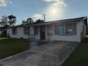 Curb view of a single story home with a grey concrete driveway and well-manicured lawn at 7200 Ravenna Ave, Orlando, FL 32819