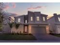 Beautiful modern two-story home featuring stone accents, a red door, a paver driveway, and manicured landscaping at sunset at 8824 Cruden Bay Ct, Davenport, FL 33896