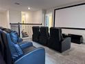 Home theater featuring tiered seating, a large screen, and comfortable leather recliners, perfect for movie nights at 8824 Cruden Bay Ct, Davenport, FL 33896