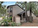 View of a two-story townhome with a gated entrance, surrounded by lush landscaping and mature trees at 940 Douglas Ave # 170, Altamonte Springs, FL 32714