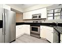 Modern kitchen with stainless steel appliances, white cabinets, and sleek black countertops at 940 Douglas Ave # 170, Altamonte Springs, FL 32714