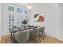 Formal dining room with a high ceiling, many windows, and a modern table and chair set at 1203 Gatwick Loop, Lake Mary, FL 32746
