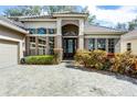 Inviting front entrance with paver walkway and manicured landscaping leading to a glass-paneled front door at 1203 Gatwick Loop, Lake Mary, FL 32746