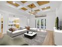 Bright living room featuring modern furnishings, coffered ceilings and sliding doors to the backyard at 1203 Gatwick Loop, Lake Mary, FL 32746