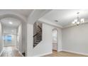 Inviting home foyer featuring arched entryways, a staircase, chandelier, and light-colored tile flooring at 16207 Point Rock Dr, Winter Garden, FL 34787