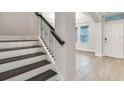 Elegant staircase with iron spindles and wood treads leading to a bright, open living space with tile flooring at 16207 Point Rock Dr, Winter Garden, FL 34787