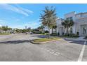 View of modern townhomes featuring well-manicured lawns, parking, and palm tree landscaping at 17442 Hidden Forest Dr, Clermont, FL 34714