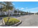 Street view of modern townhomes featuring well-manicured lawns, parking, and palm tree landscaping at 17442 Hidden Forest Dr, Clermont, FL 34714