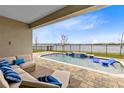 Relaxing backyard pool with a view of the lake and a comfortable outdoor seating area at 18405 Mowry Ct, Orlando, FL 32827