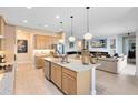 Open kitchen layout with an island, stainless steel appliances, and seamless flow into the living area at 18405 Mowry Ct, Orlando, FL 32827